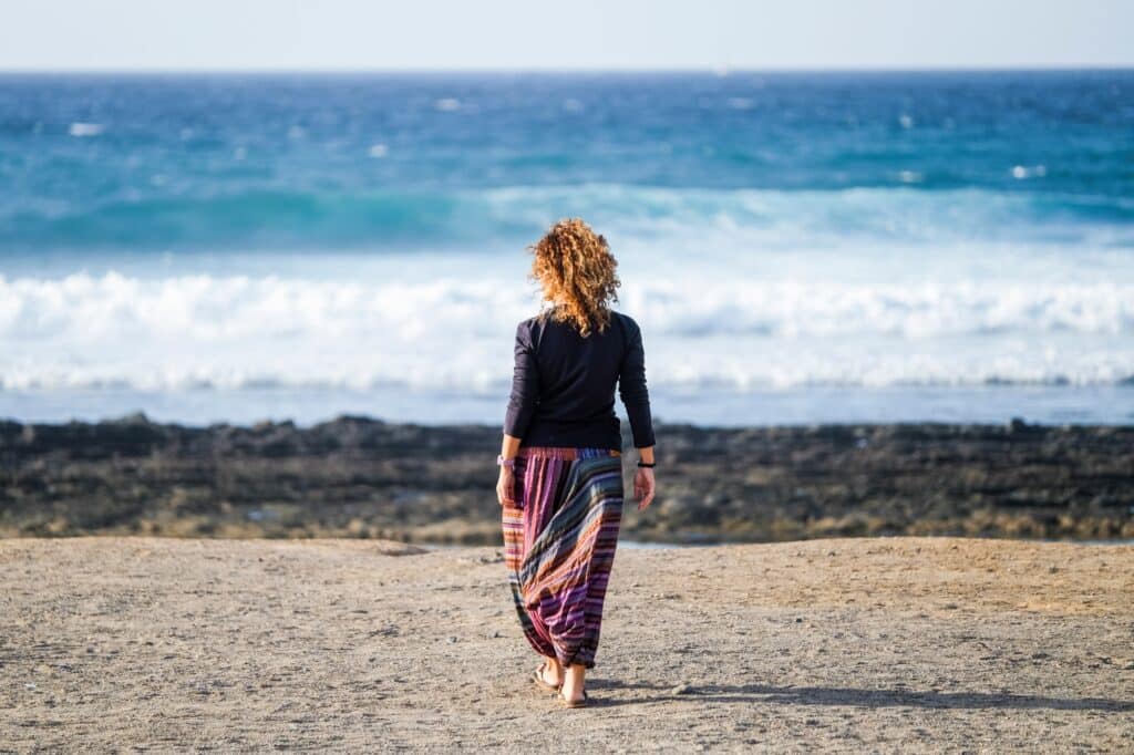 Woman walking along the beach after a benzo detox in Orange County