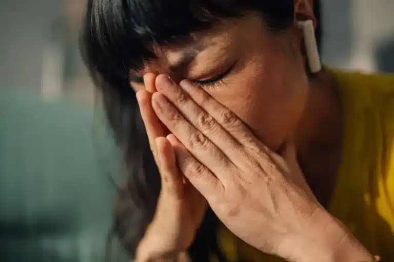 Woman with her head in her hands, representing the struggle and uncertainty many face while asking: how long does opioid withdrawal last?