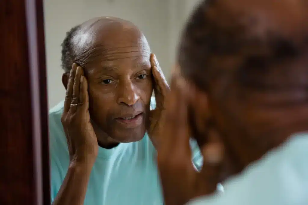 older man looking in the mirror and contemplating drug use and thinking of opioid alternatives